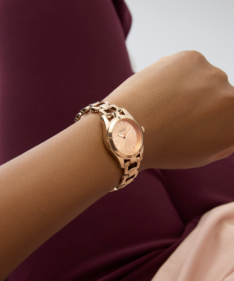GUESS Ladies Rose Gold Tone Analog Watch on a wrist with a blurred background