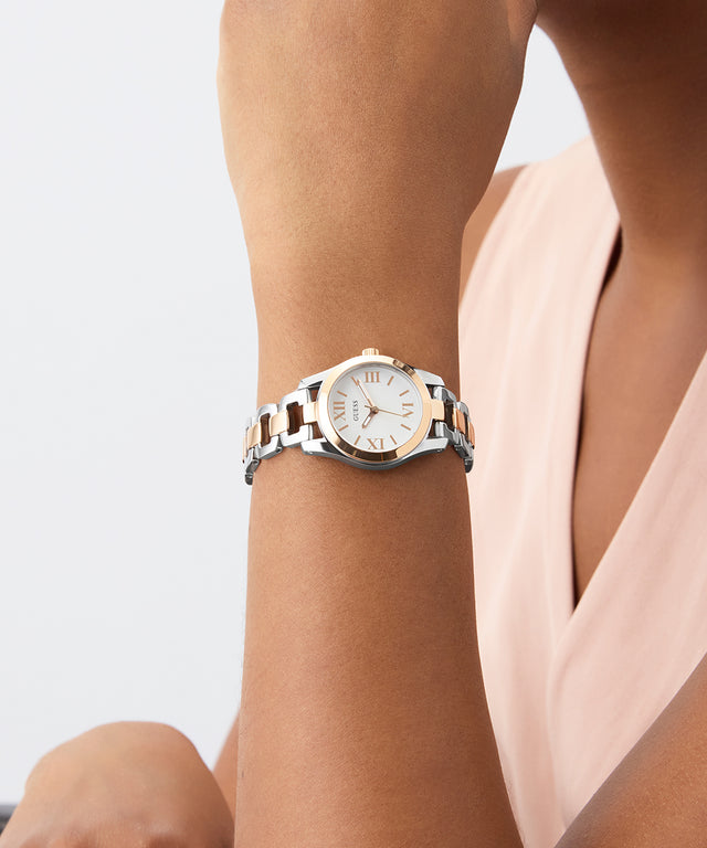 Wrist wearing a GUESS Ladies 2-Tone Analog Watch with a light background
