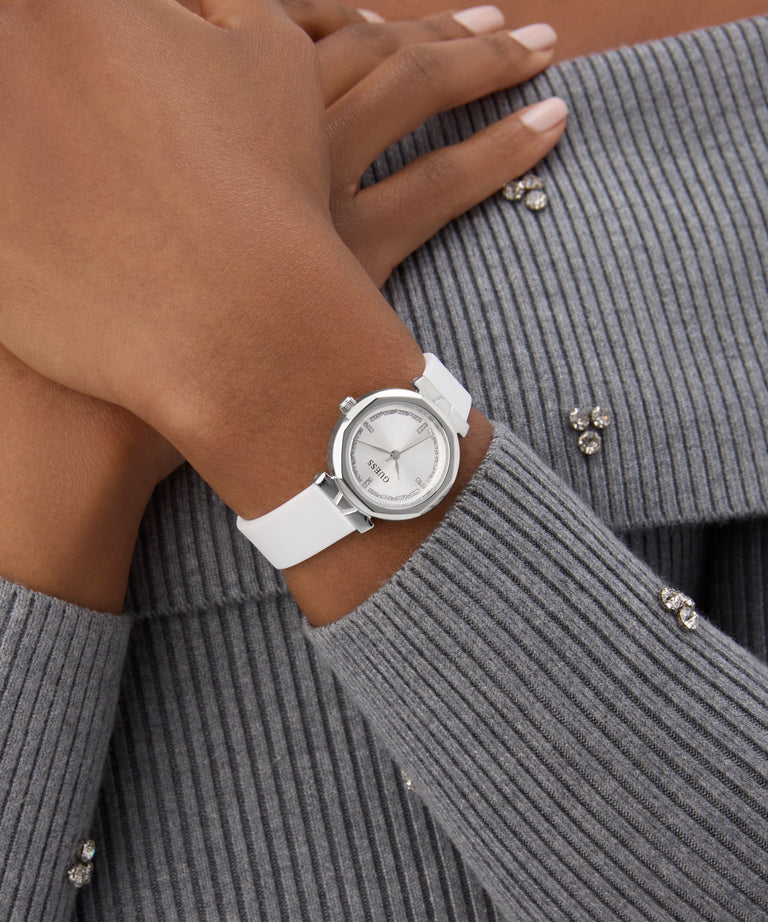 GUESS Ladies White Silver Tone Analog Watch on a wrist with a gray textured sweater