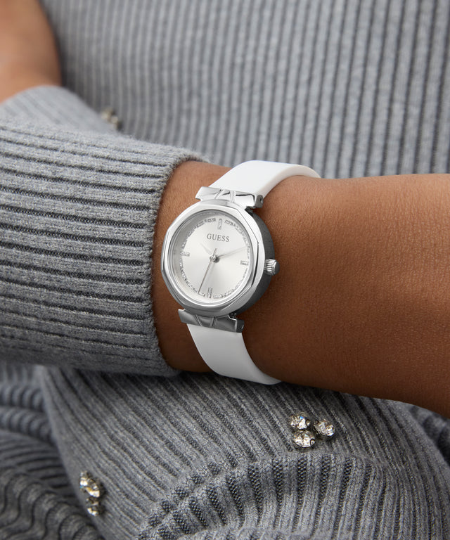 GUESS Ladies White Silver Tone Analog Watch with silver case on a person wearing a gray sweater.