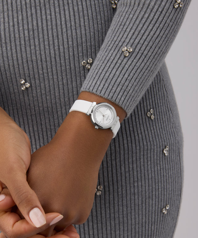 Person wearing a GUESS Ladies White Silver Tone Analog Watch on a gray background