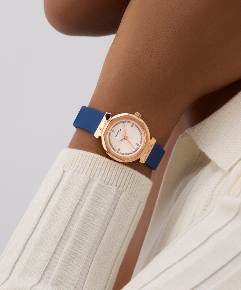 GUESS Ladies Blue Rose Gold Tone Analog Watch with a blue strap on a wrist against a neutral background