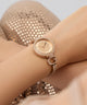 GUESS Ladies Rose Gold Tone Analog Watchwith diamond accents on a wrist against a neutral background