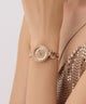 GUESS Ladies Rose Gold Tone Analog Watch with diamond accents on a wrist against a neutral background