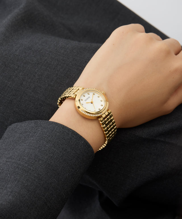 GUESS Ladies Gold Tone Analog Watch on a person's wrist with a dark background