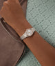 Silver watch on a wrist with a textured background