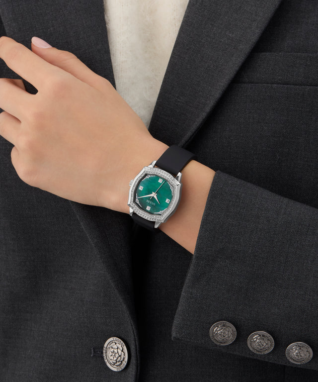 Person wearing a GUESS Ladies Black Silver Tone Analog Watch with a green face on a black suit background