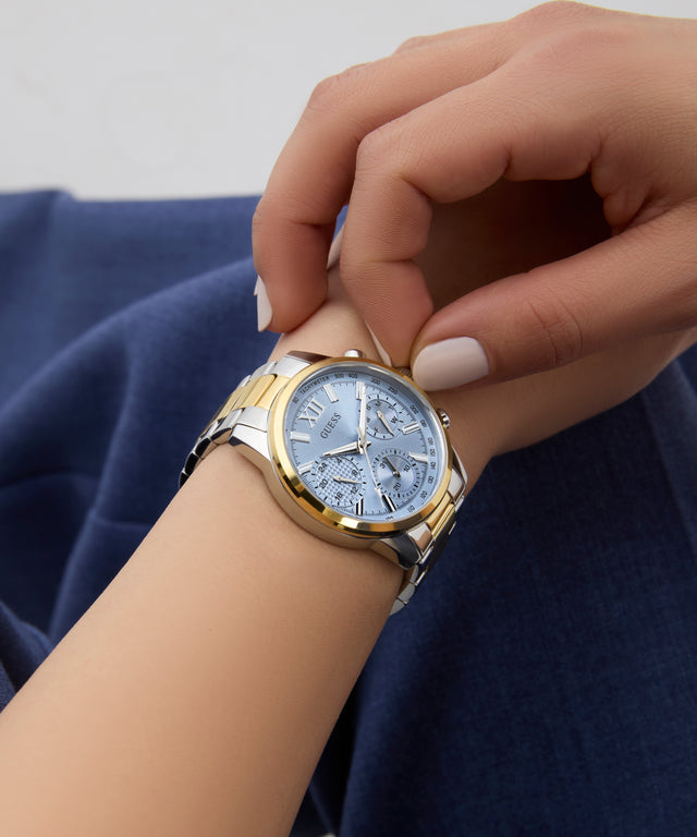 GUESS Ladies 2-Tone Multi-function Watch on a person's wrist with a neutral background
