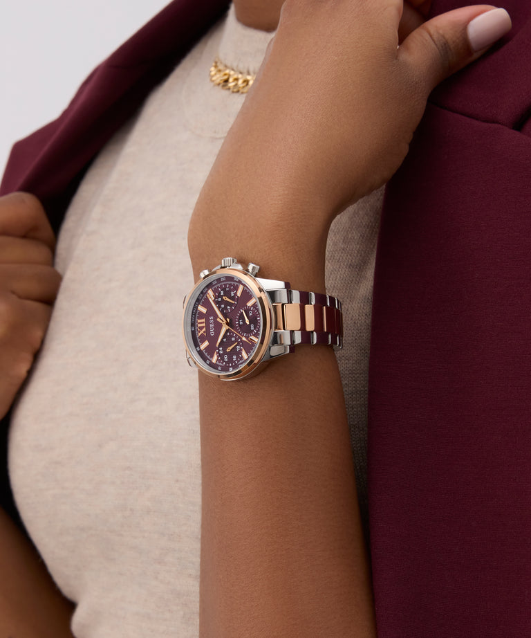 Close-up of a wrist wearing a watch with a detailed face, set against a blurred background.