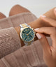 Person wearing a Guess GUESS Ladies 2-Tone Multi-function Watch on a neutral background