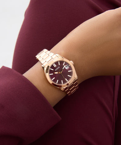 Rose gold watch on a wrist with a blurred background