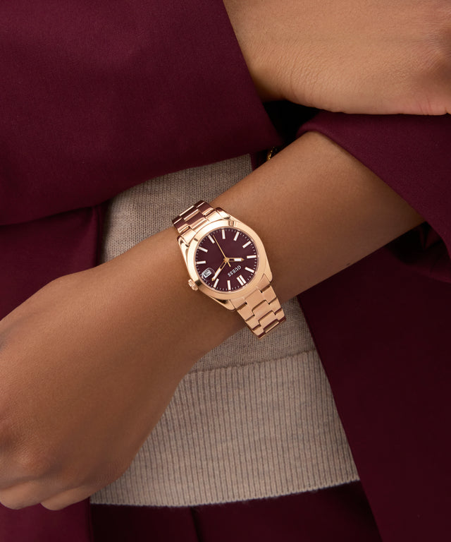 Rose gold watch on a wrist with a blurred background