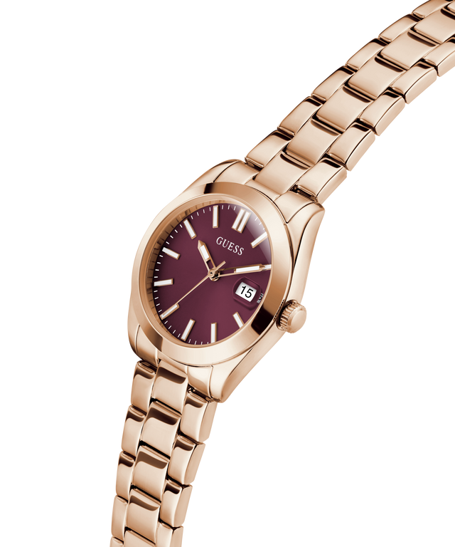 GUESS Ladies Rose Gold Tone Date Watch with a burgundy face on a white background lifestyle