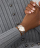 Close-up of a wrist wearing a silver GUESS Ladies 2-Tone Date Watch on a gray ribbed sweater background