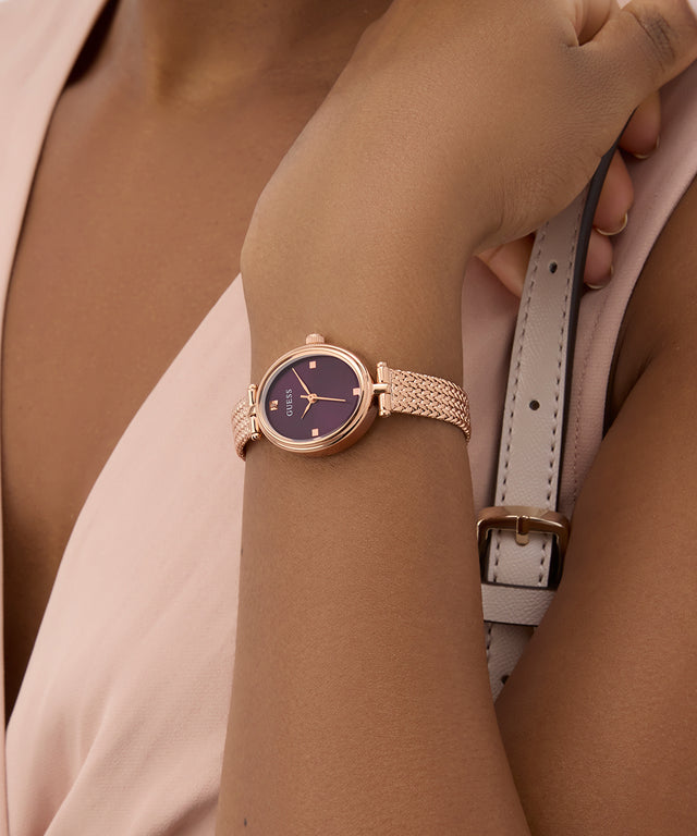 GUESS Ladies Rose Gold Tone Analog Watch on a wrist with a neutral background