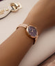 GUESS Ladies Rose Gold Tone Analog Watchon a wrist with a blurred background