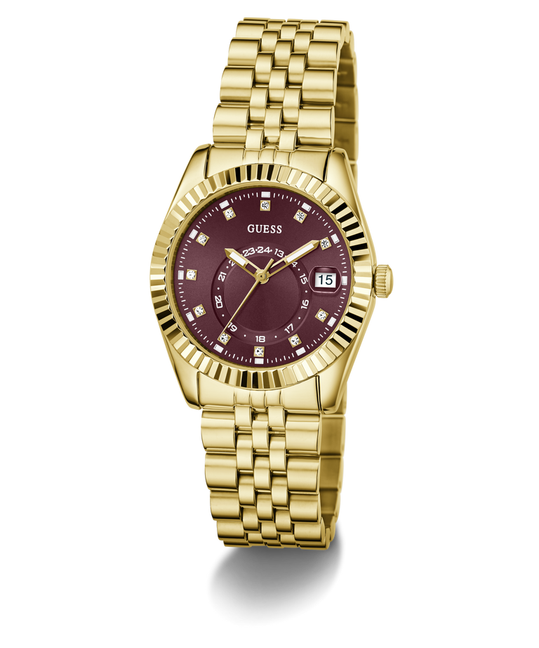 A gold-tone wristwatch with a fluted bezel, gold metal bracelet, and a deep burgundy dial with diamond hour markers and a date window at 3 o'clock. The brand name 'GUESS' is clearly visible on the dial.
