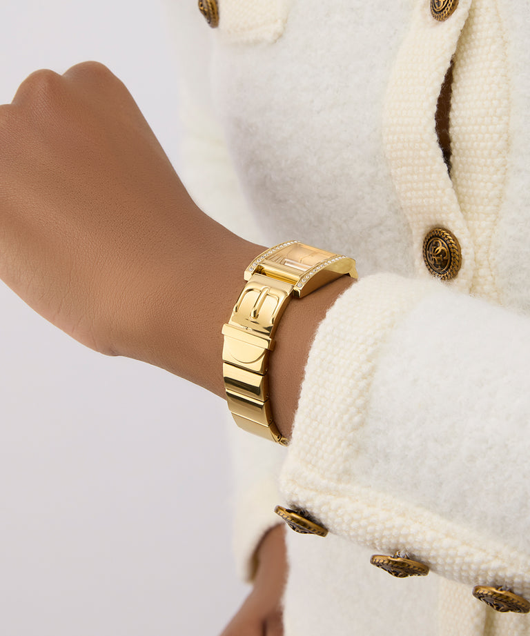 GUESS Ladies Gold Tone Analog Watch on a wrist with a white textured background