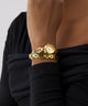 GUESS Ladies Gold Tone Analog Watch with a watch face on a person's wrist against a neutral background