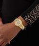 GUESS Ladies Gold Tone Analog Watch on a wrist with a black background