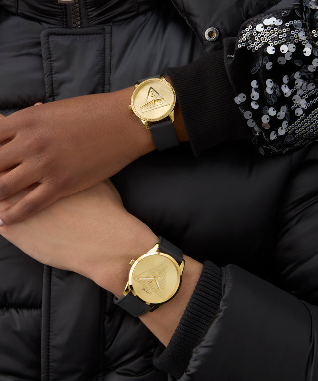 GUESS Ladies Black Gold Tone Analog Watch on a wrist with a black jacket and sequin sleeve.