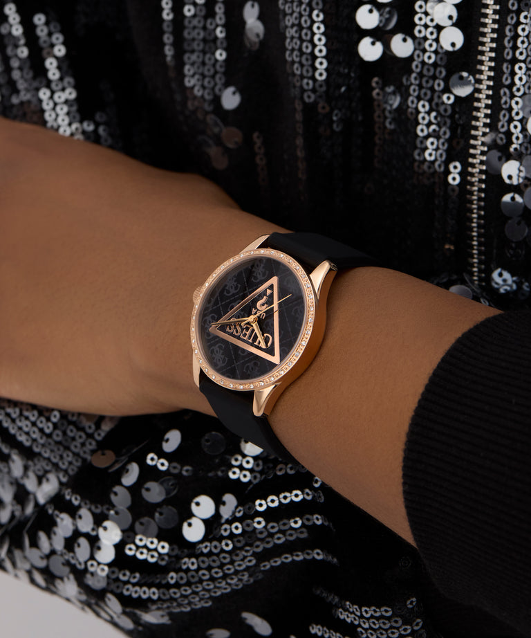 GUESS Ladies Black Rose Gold Tone Analog Watch with black strap on a wrist against a sequined background