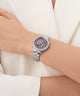 GUESS Ladies Silver Tone Analog Watch with pink face on a wrist against a white background