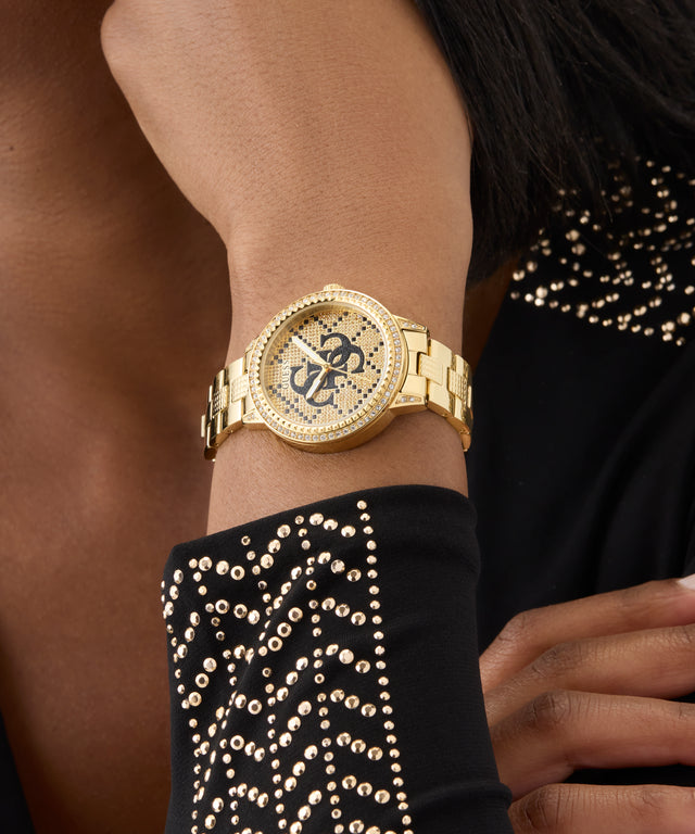 Gold watch on a wrist with a black and gold studded garment