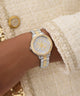 GUESS Ladies 2-Tone Analog Watch on a wrist with textured clothing background