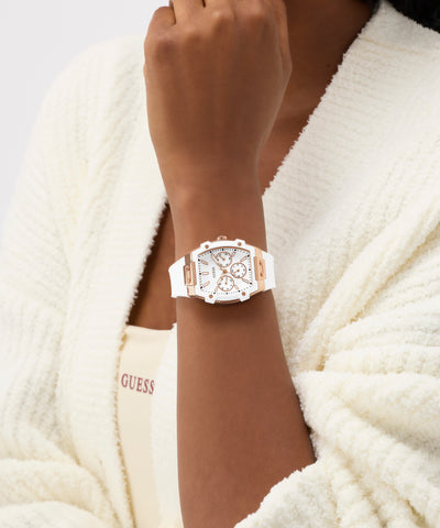 Person wearing a white GUESS Ladies White Rose Gold Tone Analog Watch on a white background