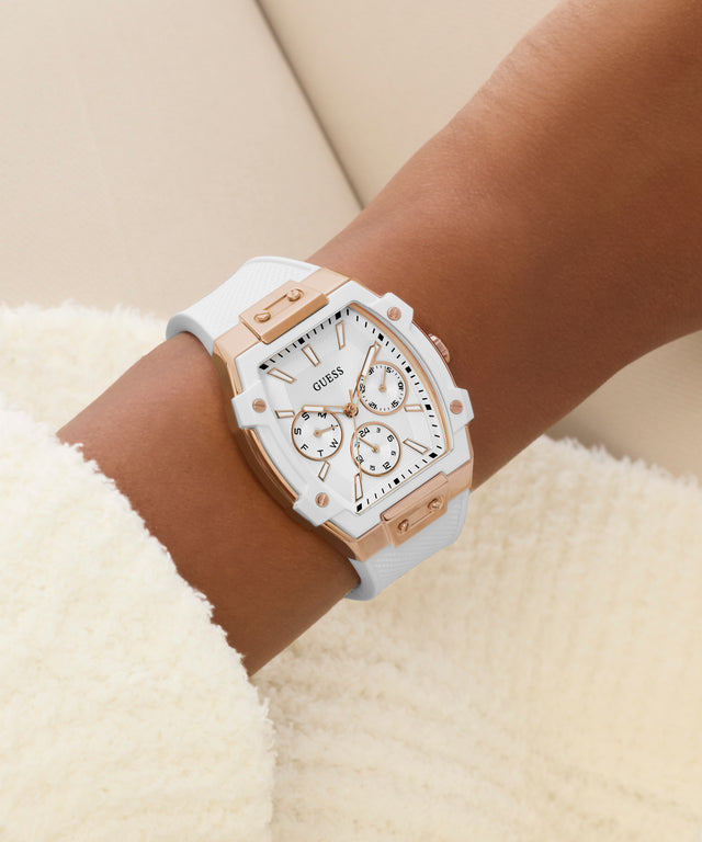 White and rose gold GUESS Ladies White Rose Gold Tone Analog Watch on a wrist with a neutral background