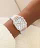 White and rose gold GUESS Ladies White Rose Gold Tone Analog Watch on a wrist with a neutral background