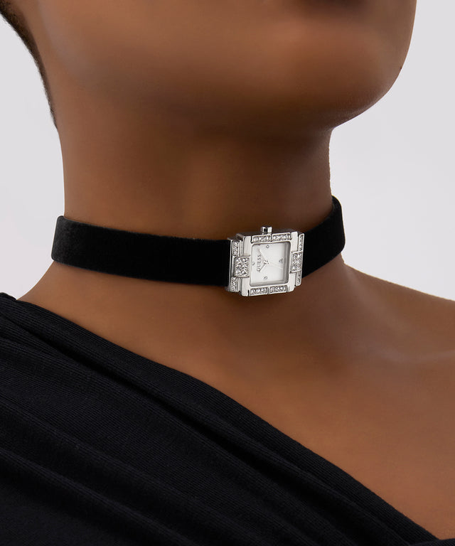 Black choker with a silver clasp worn by a person on a neutral background