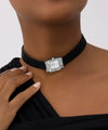 Black choker with a velvet strap and silver watch dial on a womens neck