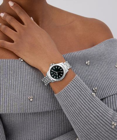 GUESS Ladies Silver Tone Analog Watch on a wrist with a gray sweater