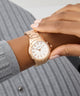 GUESS Ladies Rose Gold Tone Analog Watch on a wrist with a neutral background