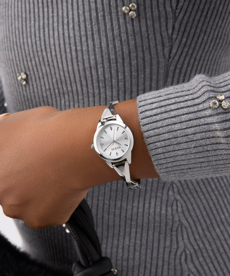 GUESS Ladies Silver Tone Analog Watch on a wrist with a gray textured sweater