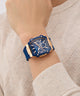 Blue and rose gold watch on a wrist against a neutral background GUESS Mens Blue Rose Gold Tone Multi-function Watch GW0956G4