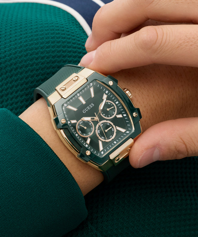 Person wearing a green and gold Guess watch on a matching green outfit.