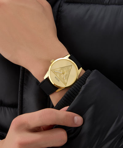Gold GUESS Mens Black Gold Tone Multi-function Watch with a black strap on a wrist, wearing a black jacket.