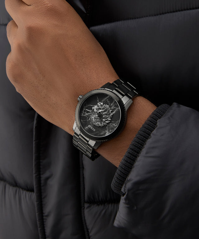 Person wearing a black watch with a detailed face on a dark background