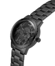 Black watch with marble-like face and Guess branding on a white background lifestyle