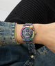 Person wearing a colorful Limited Edition Day Of The Dead watch with a black face, denim jacket, and dark background