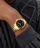 Gold watch on a wrist with a dark sweater background GW0965G2
