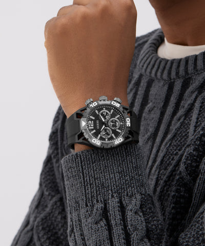 GUESS Mens Black Multi-function Watch on a person's wrist with a gray sweater