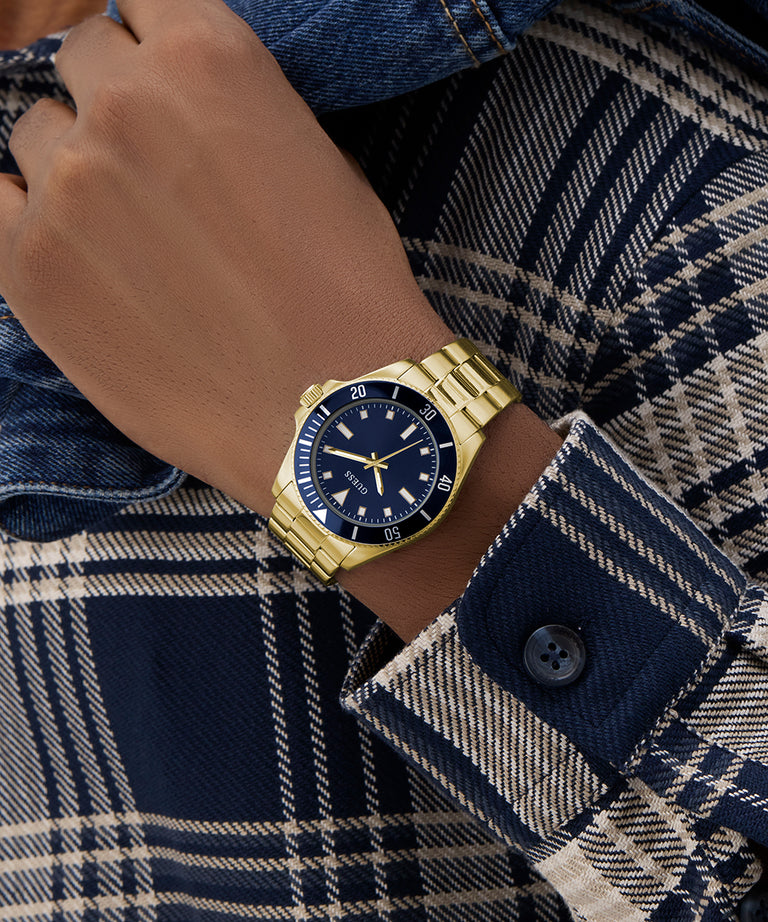 Gold GUESS Mens Gold Tone Analog Watch on a wrist with a plaid shirt
