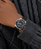 GUESS Mens Black Silver Tone Analog Watch on a person's wrist with a dark background