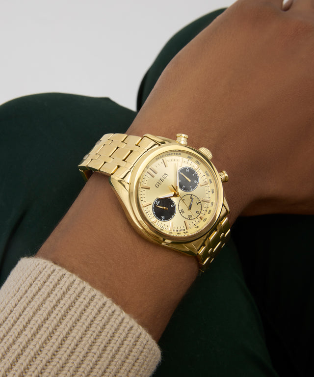 GUESS Mens Gold Tone Multi-function Watch on a person's wrist with a neutral background