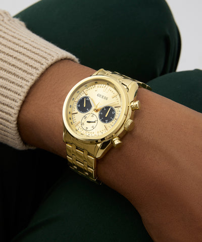 GUESS Mens Gold Tone Multi-function Watch on a wrist with a neutral background