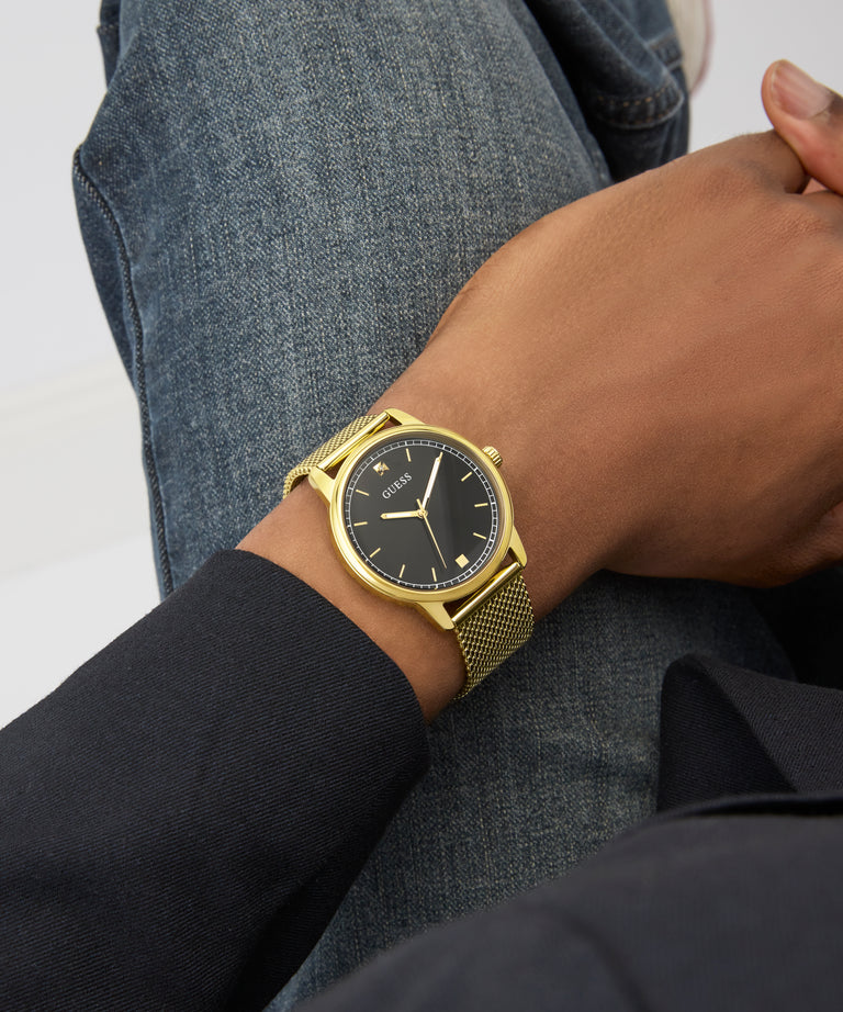 GUESS Mens Gold Tone Analog Watch on a wrist with a neutral background